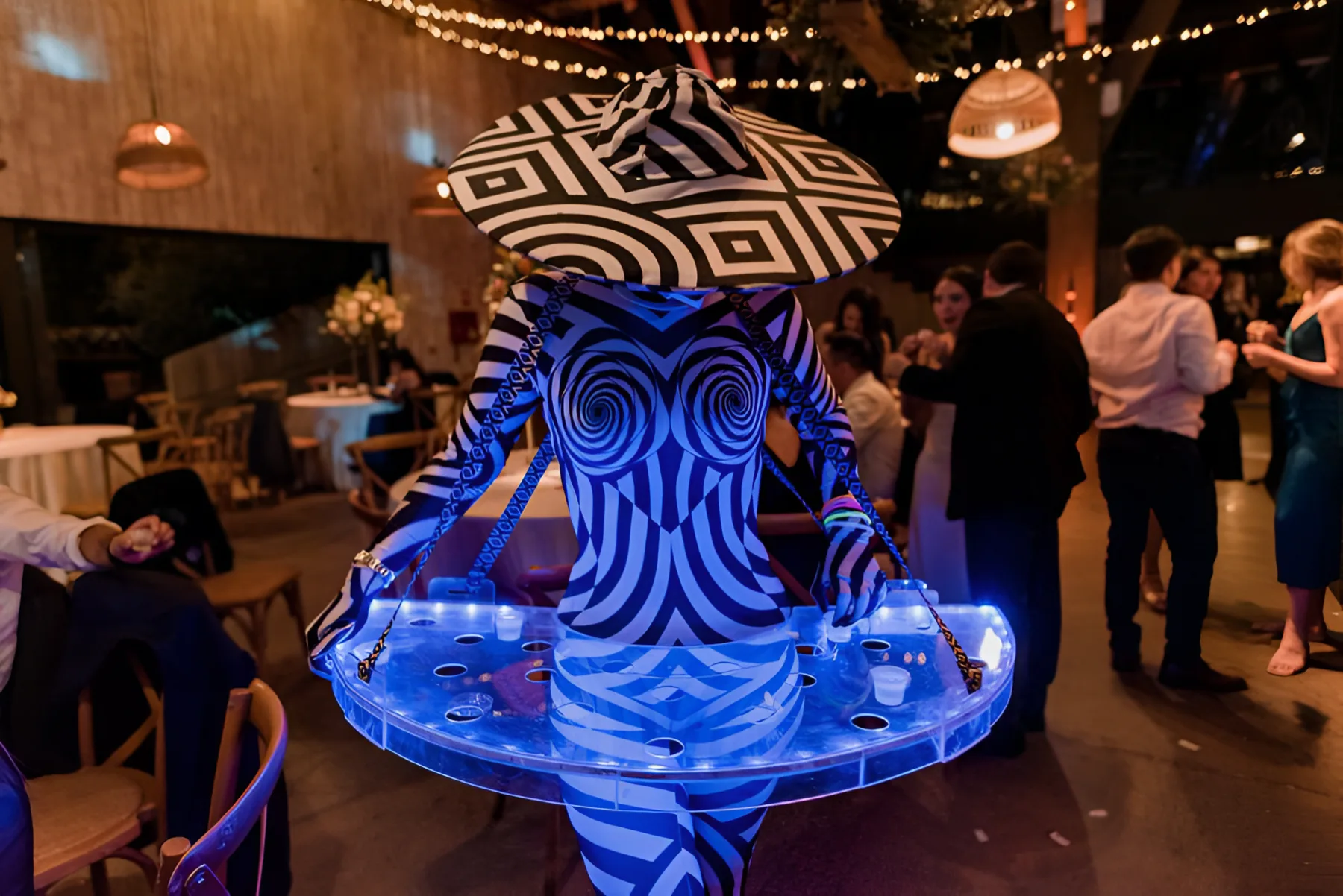 Performer con alas iluminadas en fiesta Stellar